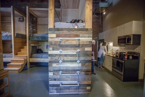 a woman standing in a kitchen with a bunk bed at PodShare DTLA in Los Angeles