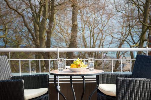 a table with a bowl of fruit on a balcony at Ringhotel Hohe Wacht in Hohwacht