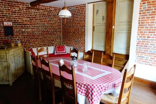 a dining room with a red and white table and chairs at La Ferme De Tigny in Tigny-Noyelle