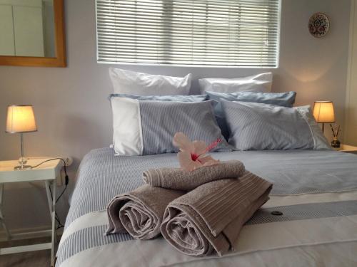 a bedroom with a bed with towels and a window at Porcupine Walk in Simonʼs Town