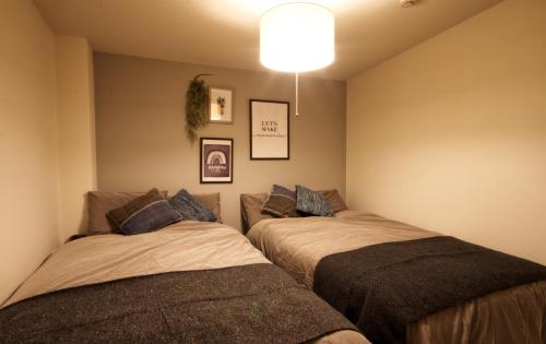 名古屋市にあるGuest House Re-worth Joshin1 2Fの部屋に2つのベッドがある