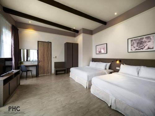 una camera d'albergo con due letti e una scrivania di Hutton Central Hotel Managed by The Ascott Limited a George Town