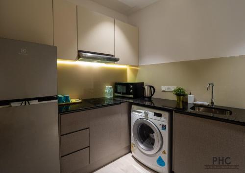a kitchen with a washing machine in a kitchen at Hutton Central Hotel Managed by The Ascott Limited in George Town