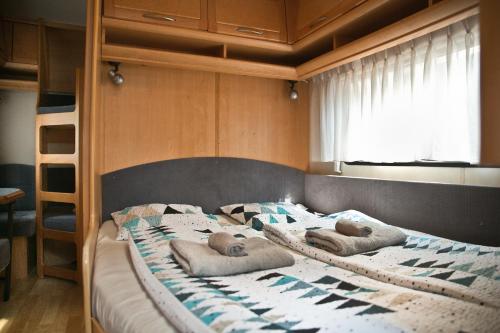 Caravans Baško Polje في باسكا فودا: غرفة نوم عليها سرير ووسادتين