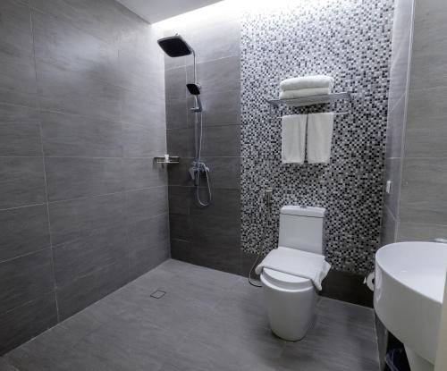 a bathroom with a shower and a toilet and a sink at One Central Hotel & Suites - Multiple Use Hotel in Cebu City