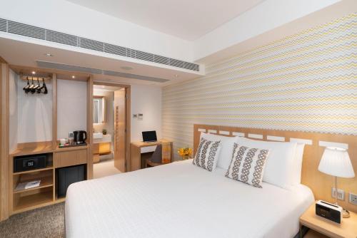 um quarto com uma cama branca e uma escrivaninha em Shama Island North em Hong Kong
