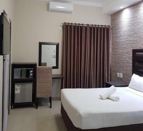 una stanza d'albergo con un letto, un tavolo e una finestra di Bayside Hotel Empangeni a Empangeni