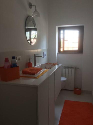 a white bathroom with a sink and a mirror at Filippo's House in Palidoro