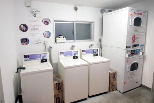 a room with two washers and two refrigerators at Sakura Hostel Asakusa in Tokyo