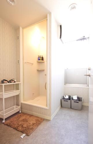 a bathroom with a shower with a glass door at Guest House Re-worth Joshin1 4F in Nagoya