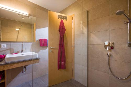 a bathroom with a shower and a sink and a red towel at Appartments Antoniushof in Ellmau