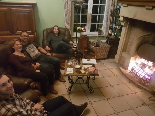 a group of people sitting in a living room with a fireplace at Château Lambert Moulinsart Hotel, shuttle airport, long term parking, snooker, large terrasse, dinner, breakfast in Charleroi