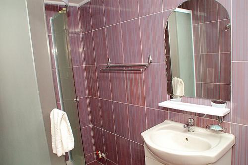 W łazience znajduje się umywalka i lustro. w obiekcie Vila Maritimo w mieście Mangalia