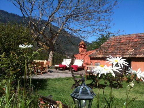 a garden with a house with a table and flowers at Rural Las Llanadas in Los Realejos