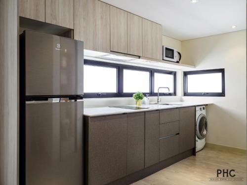 a kitchen with a stainless steel refrigerator and a dishwasher at Macallum Central Hotel Managed by The Ascott Limited in George Town