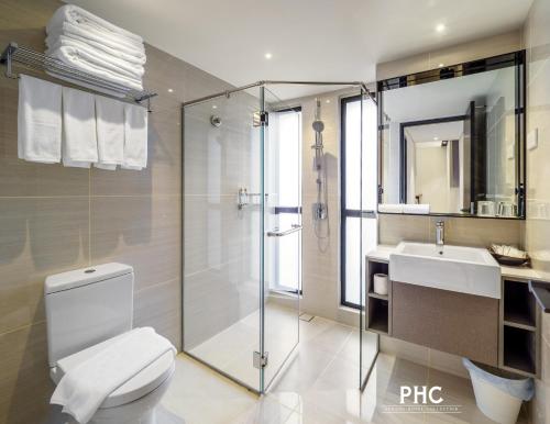 a bathroom with a toilet and a sink and a shower at Macallum Central Hotel by PHC in George Town