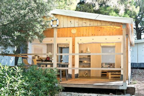 un piccolo capanno in legno con tavolo e sedie di Glamping Tents - Camp Adriatic a Primošten