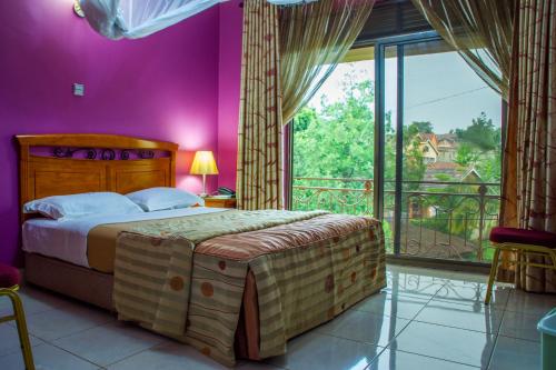a bedroom with a large bed and a large window at Landmark View Hotel in Kampala