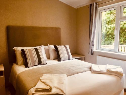 The Lodges at Sapey Golf & Country Club في Upper Sapey: غرفة نوم بسرير كبير ونافذة