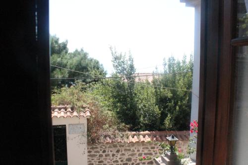 a view of a garden from a window at ΜΑΧΗ Ενοικιαζόμενα δωμάτια in Mithymna