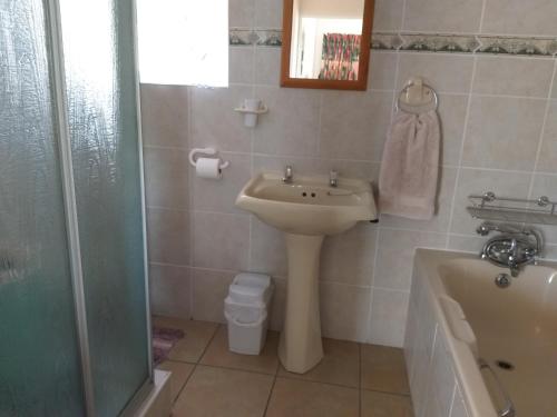 La salle de bains est pourvue d'un lavabo, d'une douche et d'une baignoire. dans l'établissement Ana's Rus, à Jeffreys Bay
