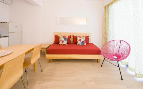 - une chambre avec un lit rouge et une table à manger dans l'établissement Apartamentos Rita, à Sant Antoni de Portmany