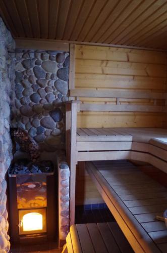 una sauna con chimenea en una cabaña de madera en Topin Tuvat, en Oravisalo