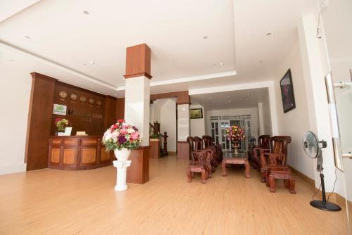 eine Lobby mit einem Tisch, Stühlen und Blumen in der Unterkunft Bong Sen Xanh Hotel in Cao Lãnh