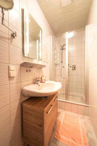a white bathroom with a sink and a shower at Ferienwohnungen Hollweger inkl. Chiemgaukarte in Ruhpolding