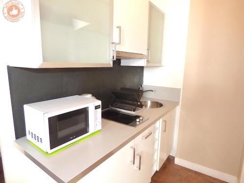 un micro-ondes posé sur un comptoir dans une cuisine dans l'établissement ALC - JJ482 - 9 min Palais and Beaches, à Cannes