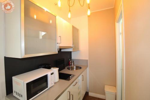 La cuisine est équipée d'un four micro-ondes blanc et d'un évier. dans l'établissement ALC - JJ482 - 9 min Palais and Beaches, à Cannes