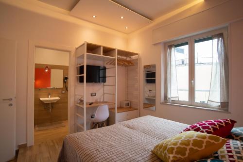 a bedroom with a bed and a bathroom with a sink at Vanvitelli Domus in Naples