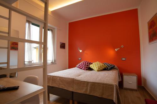 a bedroom with an orange wall and a bed with pillows at Vanvitelli Domus in Naples