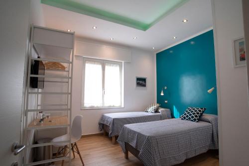 拿坡里的住宿－Vanvitelli Domus，一间设有两张床和蓝色墙壁的客房