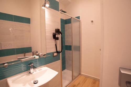 a bathroom with a sink and a glass shower at Vanvitelli Domus in Naples
