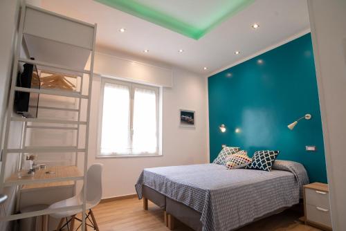 a bedroom with a bed and a blue wall at Vanvitelli Domus in Naples