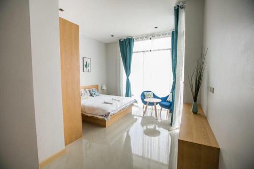 a bedroom with a bed and a window and a chair at Aonang nine poolvilla in Ao Nang Beach