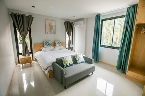 a bedroom with a bed and a couch and windows at Aonang nine poolvilla in Ao Nang Beach