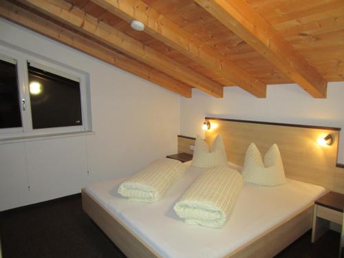a bedroom with a white bed with two pillows at Apart Steffi in See