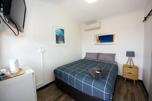 1 dormitorio con 1 cama y TV en Latitude20 Roebourne Village, en Roebourne