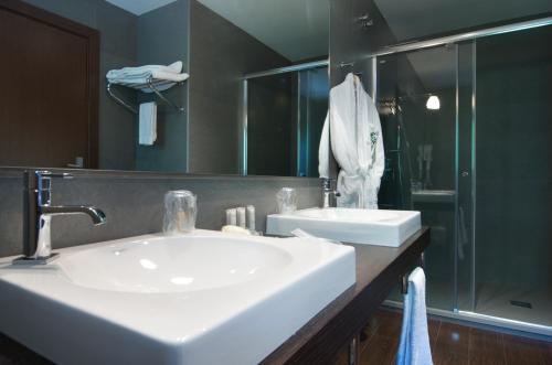 a bathroom with a white sink and a shower at Hotel Manantial in Caldes de Boi