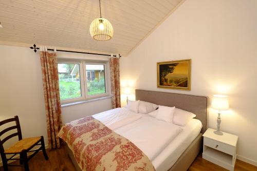 a bedroom with a bed with white sheets and a window at Hotel Gut Klostermühle natur resort & medical spa in Alt Madlitz