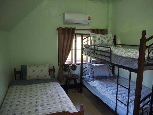 um quarto com 2 beliches e uma janela em Imm Jai Smile Cottage em Mae Chaem