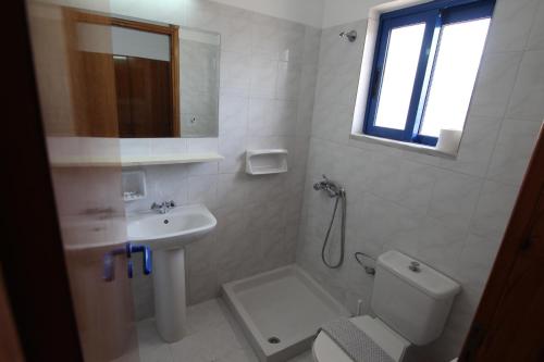 a bathroom with a sink and a toilet and a shower at Garden Hotel in Pastida