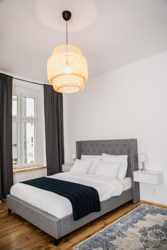 a bedroom with a large bed with a chandelier at W1 Katowice in Katowice