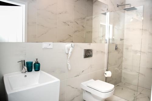 a white bathroom with a toilet and a shower at W1 Katowice in Katowice