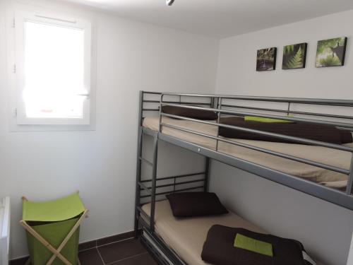 Cette chambre dispose de lits superposés, d'une fenêtre et d'une chaise. dans l'établissement La Provence Verte, à Solliès-Pont