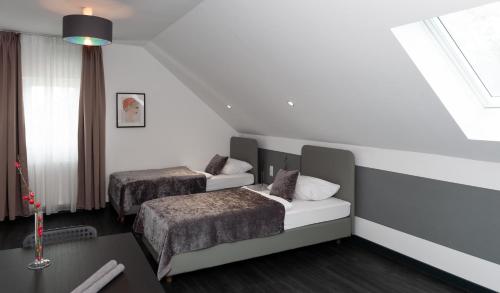 um quarto de hotel com duas camas e uma janela em Aparthotel Messe Laatzen em Hanôver