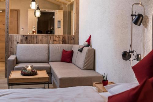 a living room with a couch and a table at Falkensteiner Hotel & Spa Falkensteinerhof in Valles