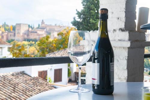 a bottle of wine sitting on a table with a glass at Carmen Aljibe de la Miel in Granada